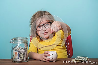 Child putting coin money into donate biggybank. Happy kid girl with her savings. Children and donation concept. Stock Photo