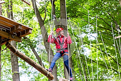 Child reaching platform climbing in high rope course Stock Photo