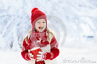 Child drinking chocolate on Christmas in snow Stock Photo