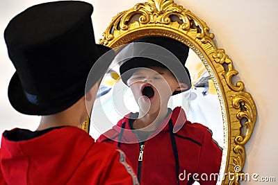 The child reflected in a distorting mirror. A fun reflection of the boy. Children`s entertainment Stock Photo