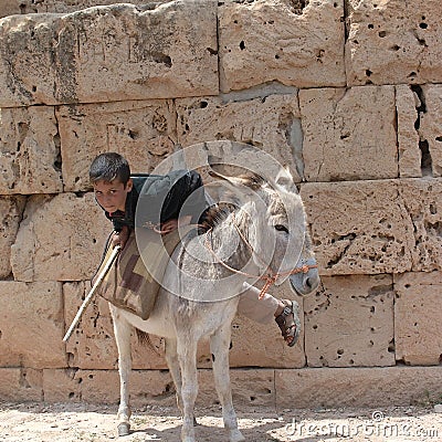 Child riding a donkey Editorial Stock Photo