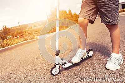 Child riding scooter outdoors. Active sport kids. Stock Photo