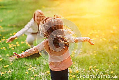 Child running into mother`s hands to hug her. Family having fun in the park. Stock Photo