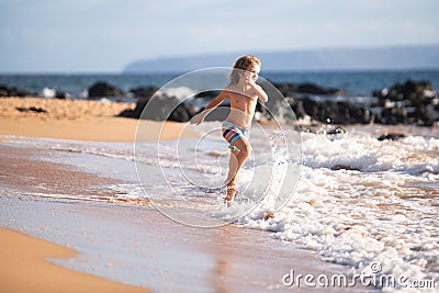 Child running through water close to shore along the sea beach. A boy runs along the sea coast. Rest of children on Stock Photo