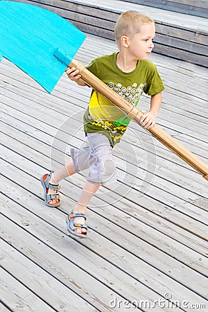 Child running with a wooden horse Stock Photo