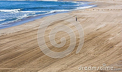 A child runs along an empty beach from the sea Spain. Tarragona Editorial Stock Photo