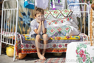 Child Russian or Ukrainian on an old ethnic bed Stock Photo