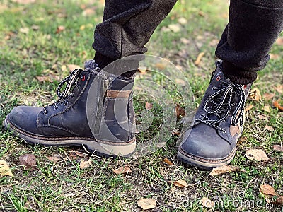 The child's feet are wearing winter lace-up shoes Stock Photo