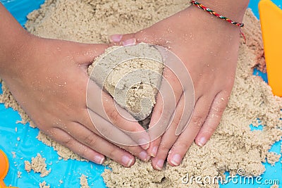 Child`s hand close up playing kinetic sand Stock Photo