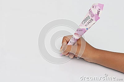 Child`s hand hold 2000 rupee note just like a pen. Stock Photo