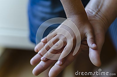 A childs hand rests on top of an adult palm Stock Photo