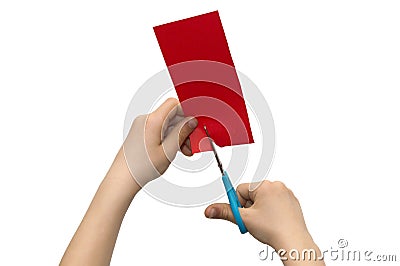 Child`s hands cutting colored red paper with scissors isolated o Stock Photo