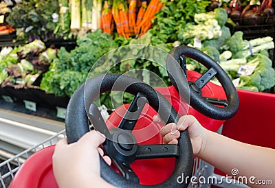 Child's hands driving shopping cart Stock Photo