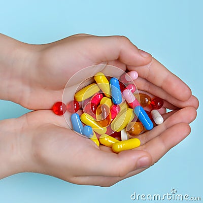 Child`s hands hold many colorful vitamins, capsules, supplements, pills Stock Photo