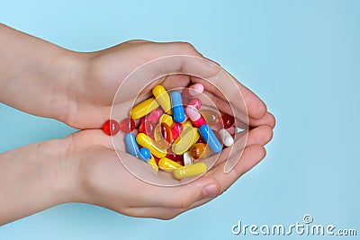 Child`s hands hold many colorful vitamins, capsules, supplements, pills Stock Photo