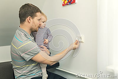 Child safety at home. father protect kid from electrical injury Stock Photo