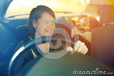 The child in a safety seat near to mother who sits on forward si Stock Photo