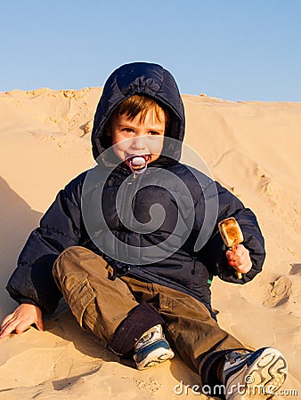 child in the Sahara desert plays with the sand of the dunes, tourist on vacation Stock Photo