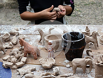 The child sculpts clay figures in the open air Stock Photo