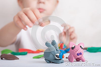 Child sculpts from plasticine pig and bunny Stock Photo