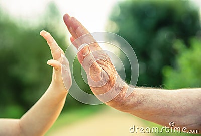 Child and senior man hands giving five in the Stock Photo