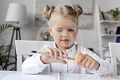 Child sharpening pencil Stock Photo