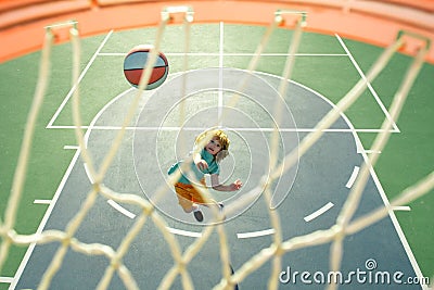 Child shooting Basketball ball and playing basketball, lower view wide angle. Basketball kids training game. Basketball Stock Photo