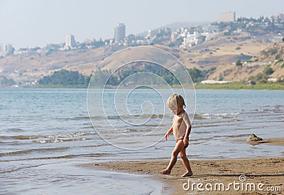 Child on the shore of lake Kinneret in the morning Stock Photo