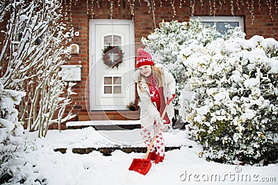 Child shoveling winter snow. Kids clear driveway Stock Photo