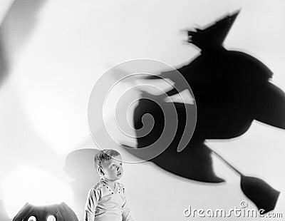 Child with silhouette of witch and jack o lantern Stock Photo