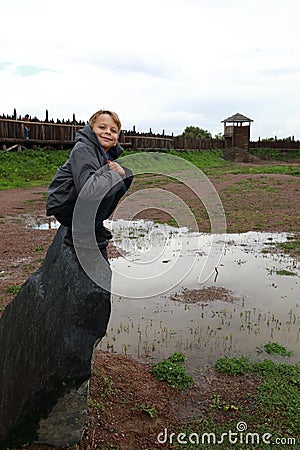 Child siting on stone in viking village Stock Photo
