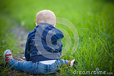 Child sitting on the green grass Stock Photo