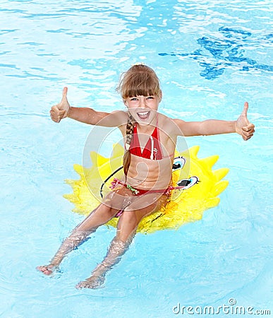 Child sitting on inflatable ring thumb up. Stock Photo