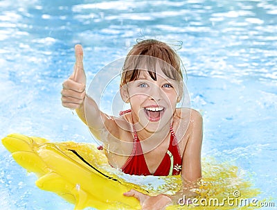 Child sitting on inflatable ring thumb up. Stock Photo