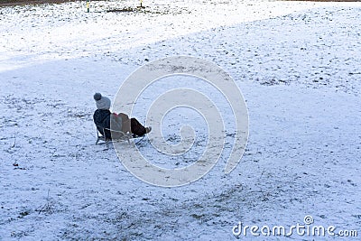 A child sledding down a hill Stock Photo