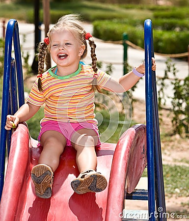 Child on slide in playground.Outdoor park. Stock Photo