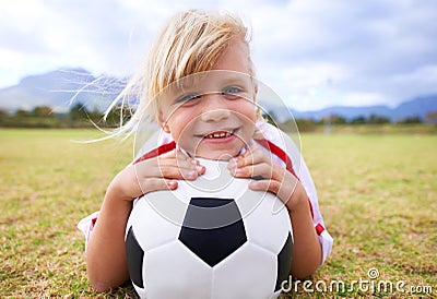 Child, soccer player and ball with portrait, smile and ready for game, field and girl. Outdoor, playful and sport for Stock Photo