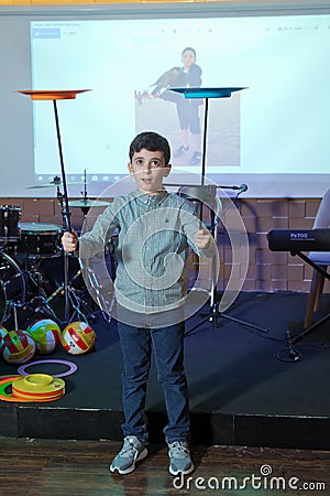 Child spinning white, blue, plates . Fun with Spinning Plates .balancing a spinning plate. Kids learning how to play spinning Editorial Stock Photo