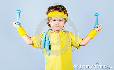 Child sportsman. Fitness for children. Boy in sportswear with skipping rope and dumbbells. Stock Photo