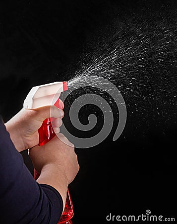 child sprays liquid from a spray bottle. Disinfection of premises during the COVID pandemic. Space for text Stock Photo