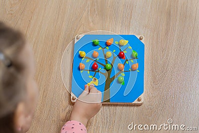 The child spreads the color of the wooden balls. Game for children Stock Photo