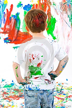 Child standing back and admiring his painting Stock Photo