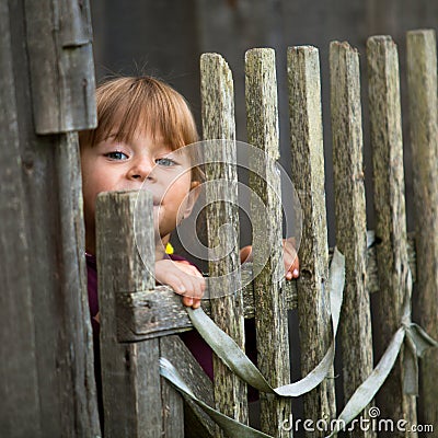 Child standing near vintage rural fence Stock Photo