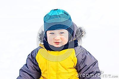 The child is standing in the winter snow over natural background Stock Photo