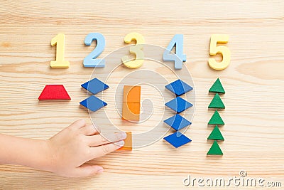 The child is studying the numbers and the account. Arranges the colored blocks to the desired numbers. Mathematics for Stock Photo