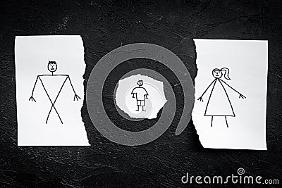 Child suffers from a divorce. Torn sheet of paper with drawn man, woman and child on black background top view copy Stock Photo