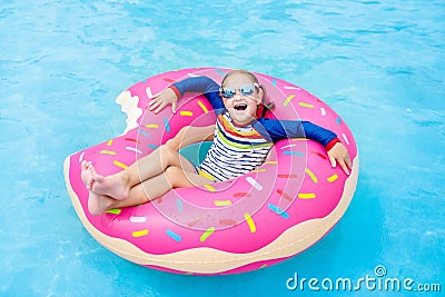 Child in swimming pool on donut float Stock Photo