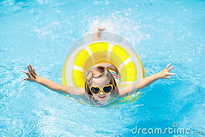 Child in swimming pool on ring toy. Kids swim Stock Photo