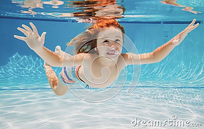 Child swims underwater in swimming pool, happy active boy dives and has fun under water, kids watersport. Summer Stock Photo