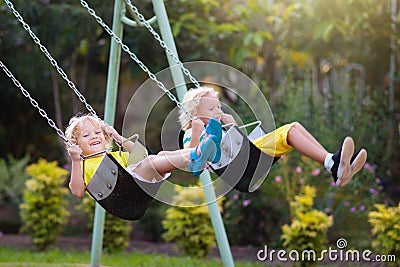 Child swinging on playground. Kids swing Stock Photo